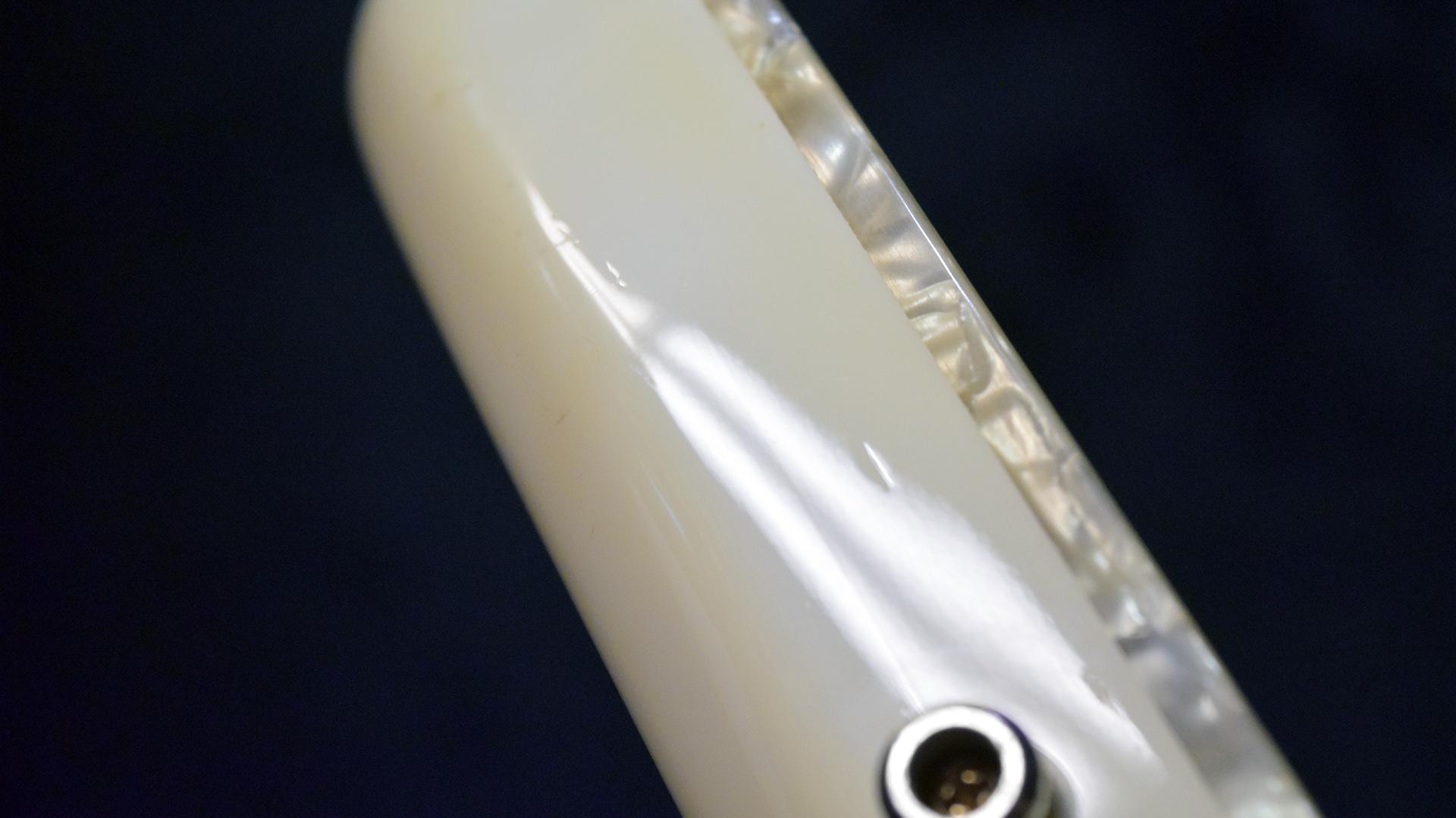Closeup detail view of TV650 WH finish pearl binding