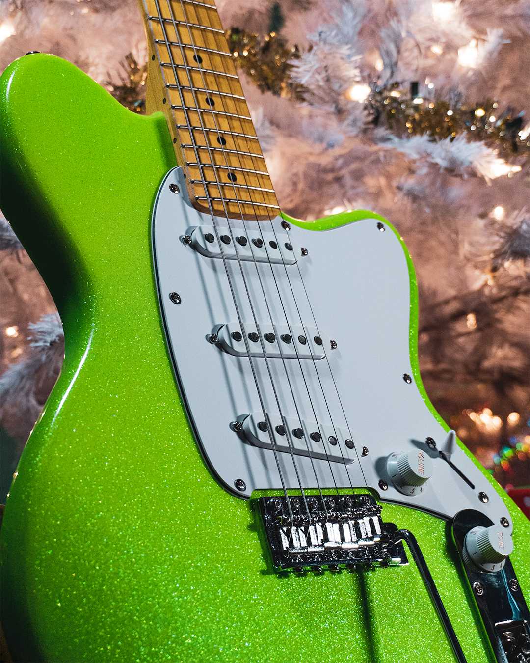 Closeup view of an Ibanez YY10, in front of a christmas tree
