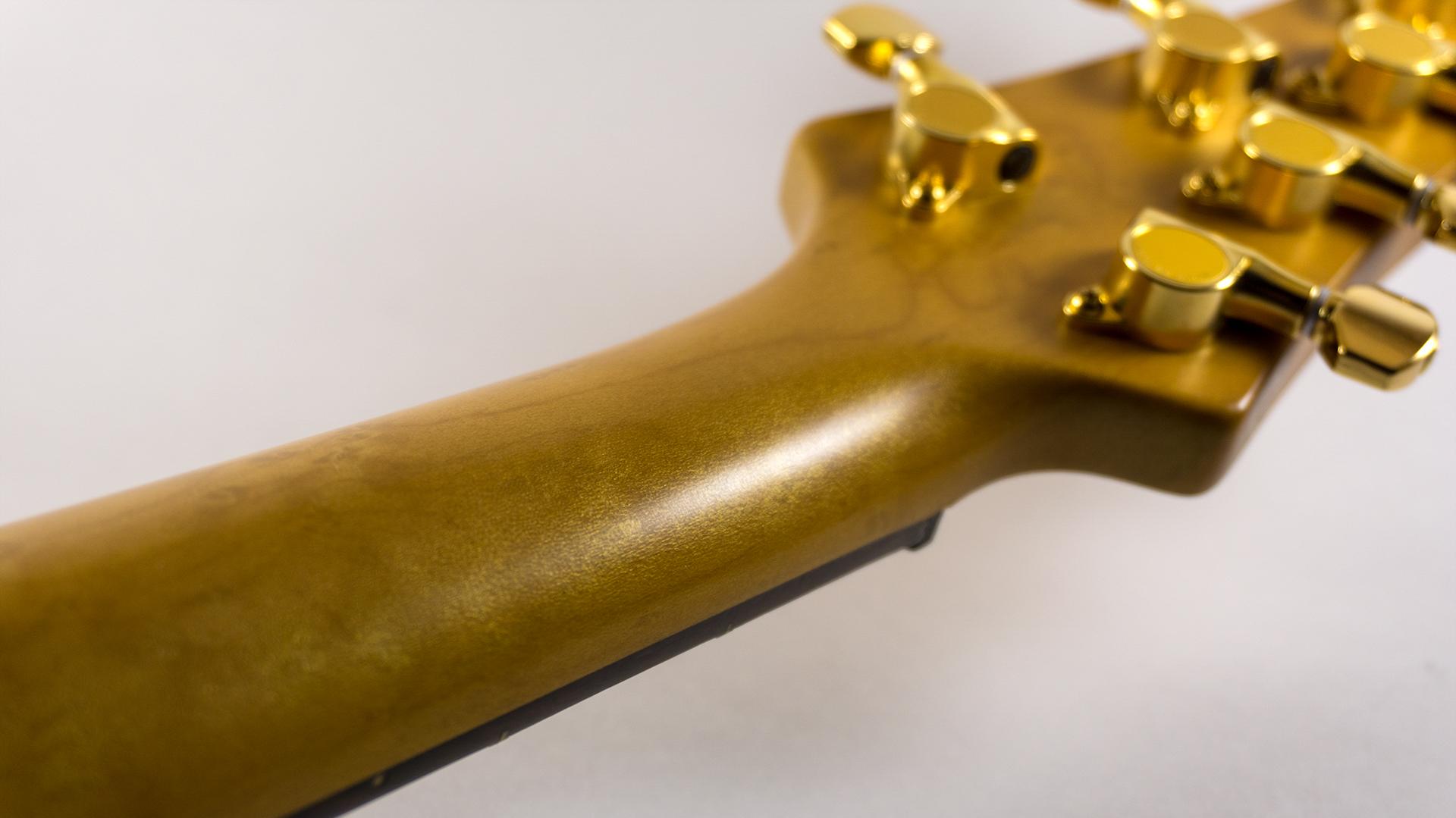 Closeup detail of gravure neck, showing golden shimmer in the finish