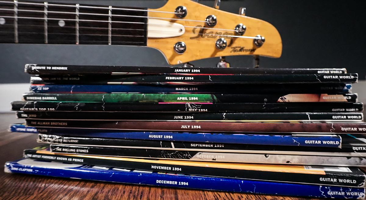 Talman headstock resting on top of a stack of guitar magazines